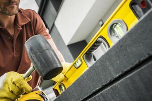 Worker Using Level Tool to Align Construction Materials Outdoors photo