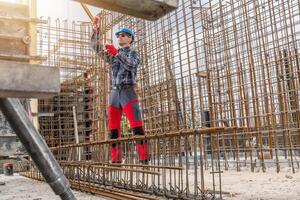 Construction Worker Managing Rebar Framework at a Building Site photo