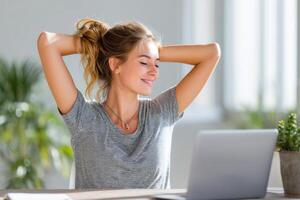Emote worker enjoying a mid-day break while relaxing at a desk with a laptop, feeling refreshed and productive in a bright and airy workspace, wellness concept photo
