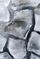 Close-up of melting textured cracked ice cubes forming abstract shapes photo