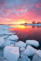 Vibrant sunset over icy river landscape with colorful clouds reflecting on water surface creating a serene winter atmosphere nature concept photo