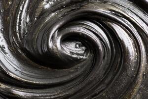 Thick black slime swirling and creating concentric circles photo