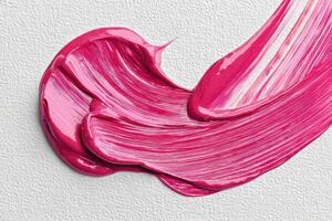 Vivid pink paint smear on monochrome canvas creating abstract art photo