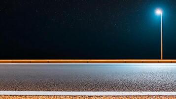 Nighttime highway scene with illuminated streetlight, clear road, and starry sky above photo