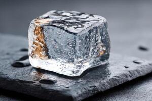 Ice cube resting on a dark stone surface with droplets of water, showcasing its clarity and texture, perfect for beverage cooling, ice concept photo