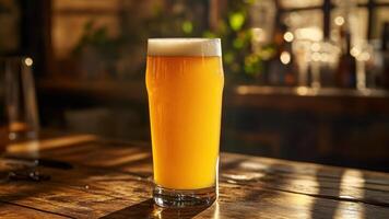 A Refreshing Pint of Golden Beer Sits on a Wooden Bar Under Warm Sunlight photo