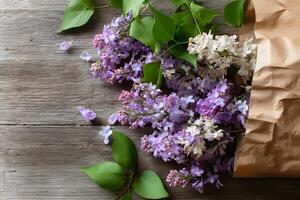 Delicate lilac blooms peeking from a rustic brown paper bag on a weathered wooden surface, ready for your message. photo