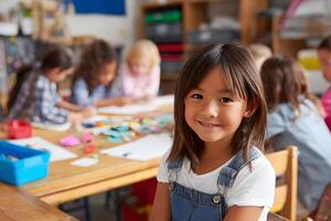 Confident young girl smiling at viewer while working on writing task with classmates and creative materials around desks photo