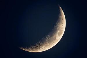 Delicate crescent moon glowing softly in the twilight sky, surrounded by shimmering stars. photo