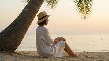 Bob hairstyle. Woman with bob hairstyle sitting under coconut tree shade on tropical beach, ideal for travel websites or summer blogs. photo