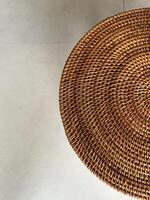 Woven round table with intricate patterns placed on a smooth surface photo