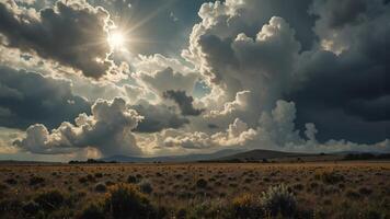 Dramatic Cloudscape Over Open Field with Sunlight and Mountains photo