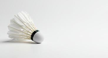 White badminton shuttlecock on a white surface ideal for sports, fitness, badminton, equipment, sports equipment, recreation, competition, and training concepts. photo