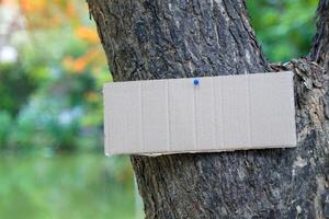 Crate paper sign on the tree for writing environmental campaign messages and forest conservation photo