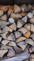 Stacked firewood neatly arranged for drying, rustic wooden logs prepared for heating, natural texture and earthy tones in a warm storage space video
