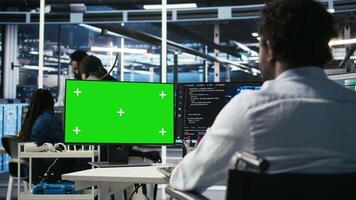 Data center engineer with paraplegia using AI deep learning algorithms on green screen PC to analyze datasets. Server room worker in wheelchair at chroma key PC using AI neural networks, camera A video
