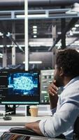 Vertical Admin in wheelchair and data center coworker working together using AI node tree software to minimize downtime. Server hub IT expert in disability and colleague using visual programming app, camera A video