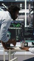 Pleased data center manager praising work done by engineer using neural network models to configure hardware. Supervisor congratulating employee for successfully using AI to optimize system, camera A video