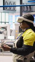 Vertical Engineer working in industry 4.0 plant using virtual reality technology to check equipment. Smart factory employee using VR headset to manage and upgrade automation systems, camera A video
