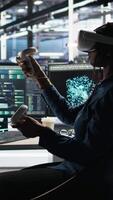 Vertical Server farm admin using VR equipment and node tree systems to categorize unstructured data. Data center IT specialist uses virtual reality headset and visual programming software, camera A video