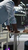 Server hub manager checking data analytics graphs, congratulating worker. Data center team leader doing fist bump with admin using artificial intelligence showing system metrics, camera A video