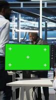 Vertical Data center worker with paraplegia using green screen PC to apply node tree programming. Server hub admin with disability uses visual programming on mockup computer to identify data patterns, camera A video
