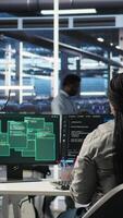 Vertical Server farm engineering team collaborating to protect against data theft during cyberattack. Data center coworkers rushing to safeguard infrastructure systems during security breach, camera A video