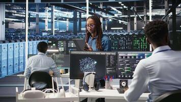 Portrait of upbeat server hub software developer using node tree software to optimize system health. Radiant data center staff member analyzing rigs issues using AI visualization, camera A video