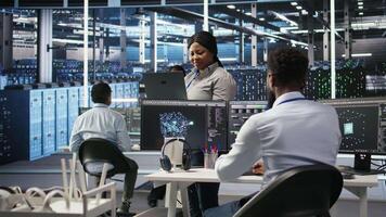 Data center computer scientists use node tree programming to identify equipment performance issues. Server farm employees review data analysis graphs to minimize infrastructure failures, camera A video