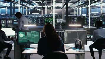Vertical Server hub engineering team rushes to stop cyberattack targeting confidential information. Data center colleagues working together during security breach to contain virus and protect systems, camera A video