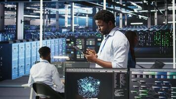Server farm technician using AI algorithms and node tree systems to categorize unstructured data. Data center worker uses visual programming and natural language processing tools, camera A video