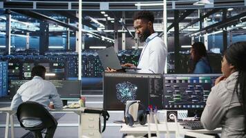 Data center programmer uses node tree software to identify equipment performance issues. African american server farm worker reviews data analysis graph to minimize hardware failures, camera A video
