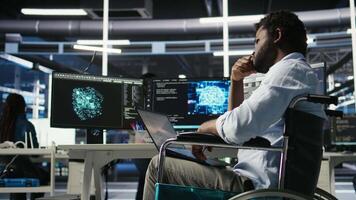 Vertical Data center computer scientist in wheelchair using AI node tree software to minimize system downtime. Server hub employee in disability using artificial intelligence visual programming tool, camera A video
