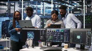 Smiling server hub engineers collaborating, using AI algorithms and node tree systems to categorize unstructured data. Colleagues use visual programming and natural language processing tools, camera A video
