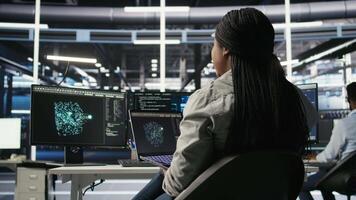 Server room IT expert using laptop to apply artificial intelligence technology minimizing system downtime. Technician using notebook to develop and deploy AI solutions optimizing equipment, camera A video