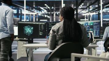 Data center admin does neural networks node tree programming, optimizing resource allocation. Server room IT professional uses predictive deep learning AI visualization systems, camera A video