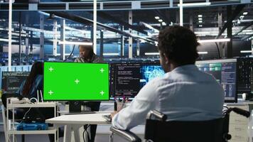 Data center admin in wheelchair using AI node tree software on green screen PC to minimize system downtime. Server hub employee in disability using visual programming tool on mockup computer, camera A video