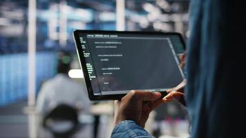 fechar acima do servidor quarto programador verificação codificação em tábua realçando operacional eficiência e reduzindo tempo de inatividade. desenvolvedor verificando programação língua roteiro usava para atualizar engrenagem, Câmera uma video