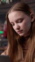 Vertical Female student makes final preparations for her university periodicals, combining research on books from the academy database and handwritten notes. Educated girl studying. Camera B. video