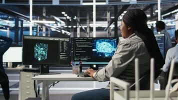 Data center computer scientist using artificial intelligence deep learning models to configure hardware. IT specialist using AI programming languages on PC in server farm, optimizing system, camera A video