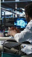 Impatient engineer with paraplegia in data center annoyed by slow AI node tree software. Upset server hub worker with disability frustrated by buggy visual programming tool, camera A video