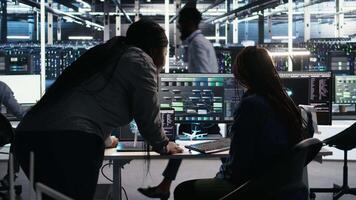 Data center teamworking colleagues use node tree program to identify equipment performance issues. Server hub engineering team coworkers review data analysis graph to minimize failures, camera A video