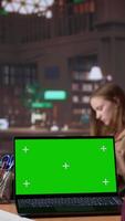 Vertical Young student working with a green screen in the university campus library, collecting academic information from verified educational sources. Pupil using research tools. Camera B. video