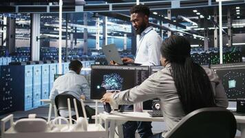 Portrait of cheerful data center engineer analyzing gear issues using node tree tools. Upbeat African american server hub specialist using AI visualization insights to optimize system health, camera A video