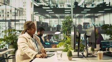 Joyous coworkers having fun in vibrant office while reviewing financial graphs. Cheerful colleagues sharing jokes while working, looking over data trends and strategic insights, camera B video