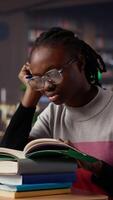 Vertical Exhausted student falling asleep while she reads for periodical exams at the college, working hard for diploma with excellent marks. Tired pupil studying all night before first grade. Camera A. video