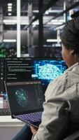 Data center admin uses AI technology on laptop for machine learning workloads. Server hub worker using artificial intelligence on notebook to perform demanding computing tasks, camera A video