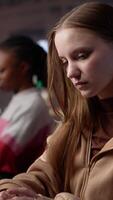 Vertical Student struggling to stay focused and awake while she does her research, writing on bachelor paper in the library to obtain college diploma. Girl working hard for a certificate. Camera A. video