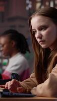 Vertical Diverse classmates sharing high five and feeling happy with their success, finishing school assignment in time and expecting a high grade. Girls doing amazing teamwork at the library. Camera A. video