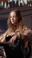 Vertical Female college student reads and writes detailed notes for a new course, studying political science for upcoming lecture in a library setting at university. Girl consults database. Camera A. video